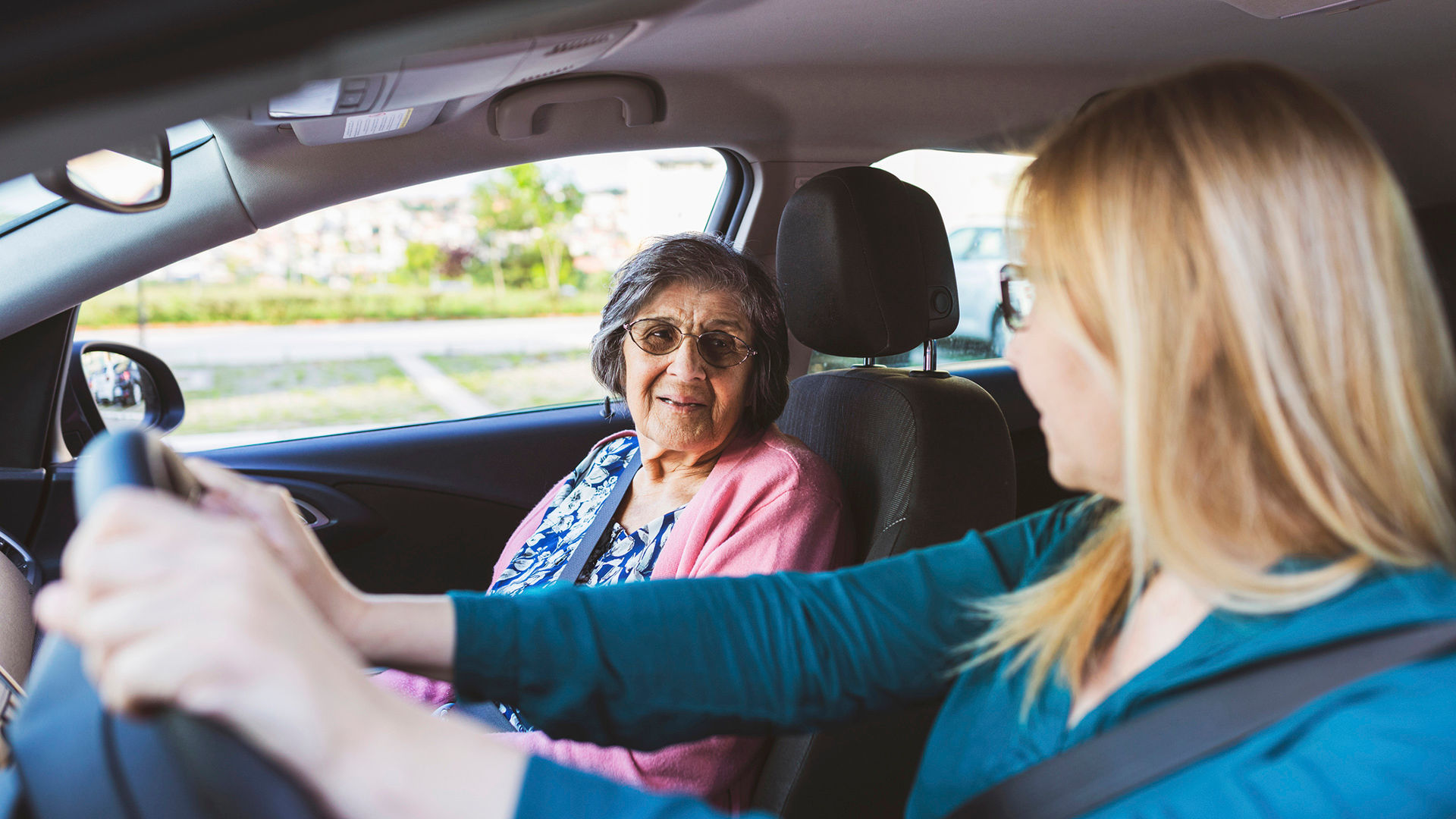 Mature woman in a car with her senior mother.They are talking and enjoy in a ride Health care and protection.