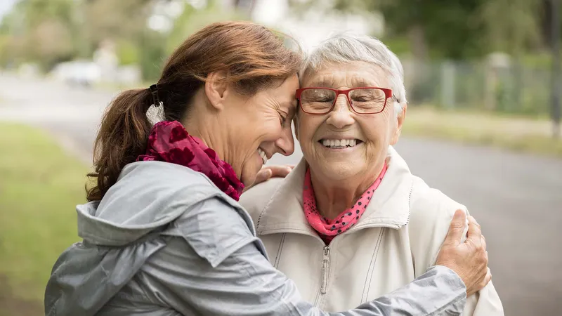A woman and her daughter hugging and smiling together