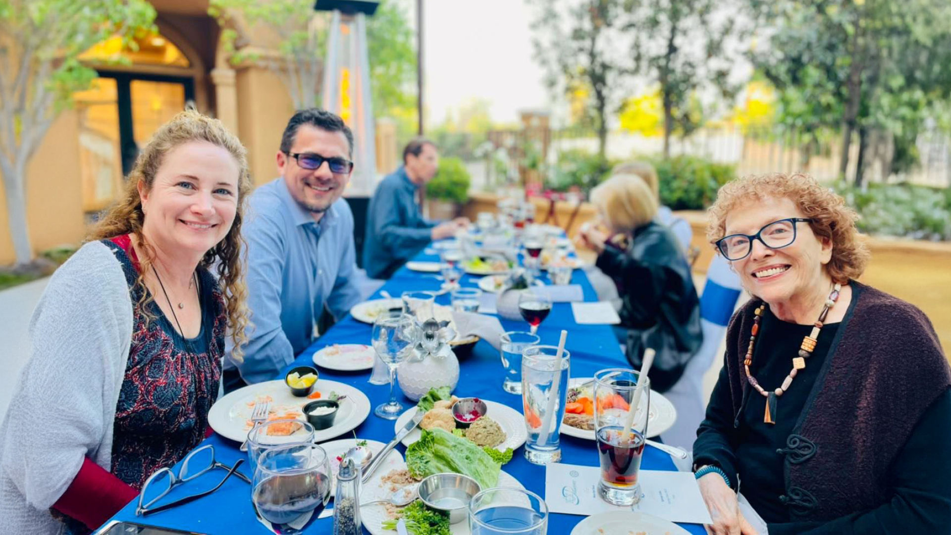Atria Tarzana residents and resident families celebrating Purim at a dining table together