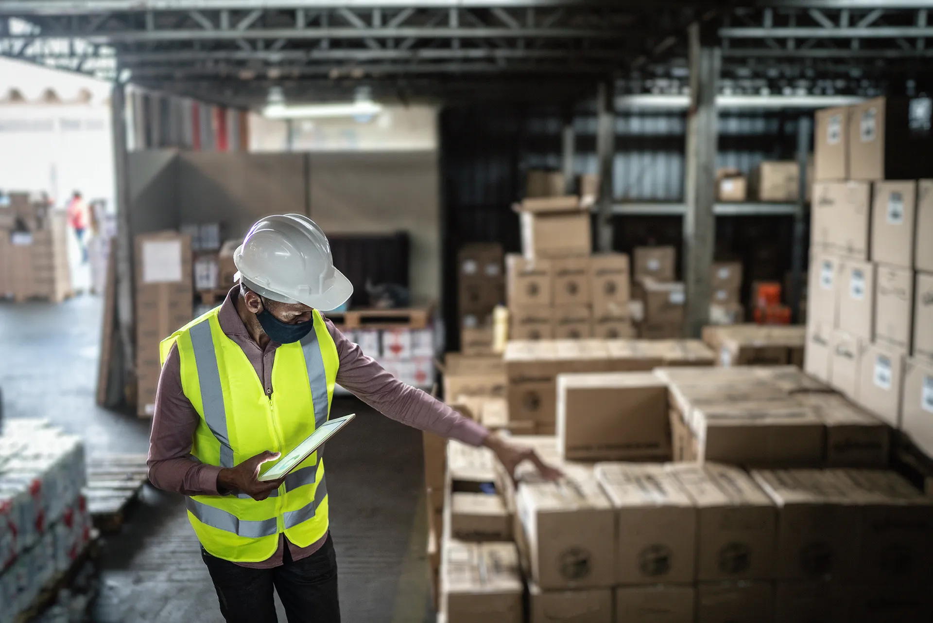 Man in hardhat working with boxes in storage area