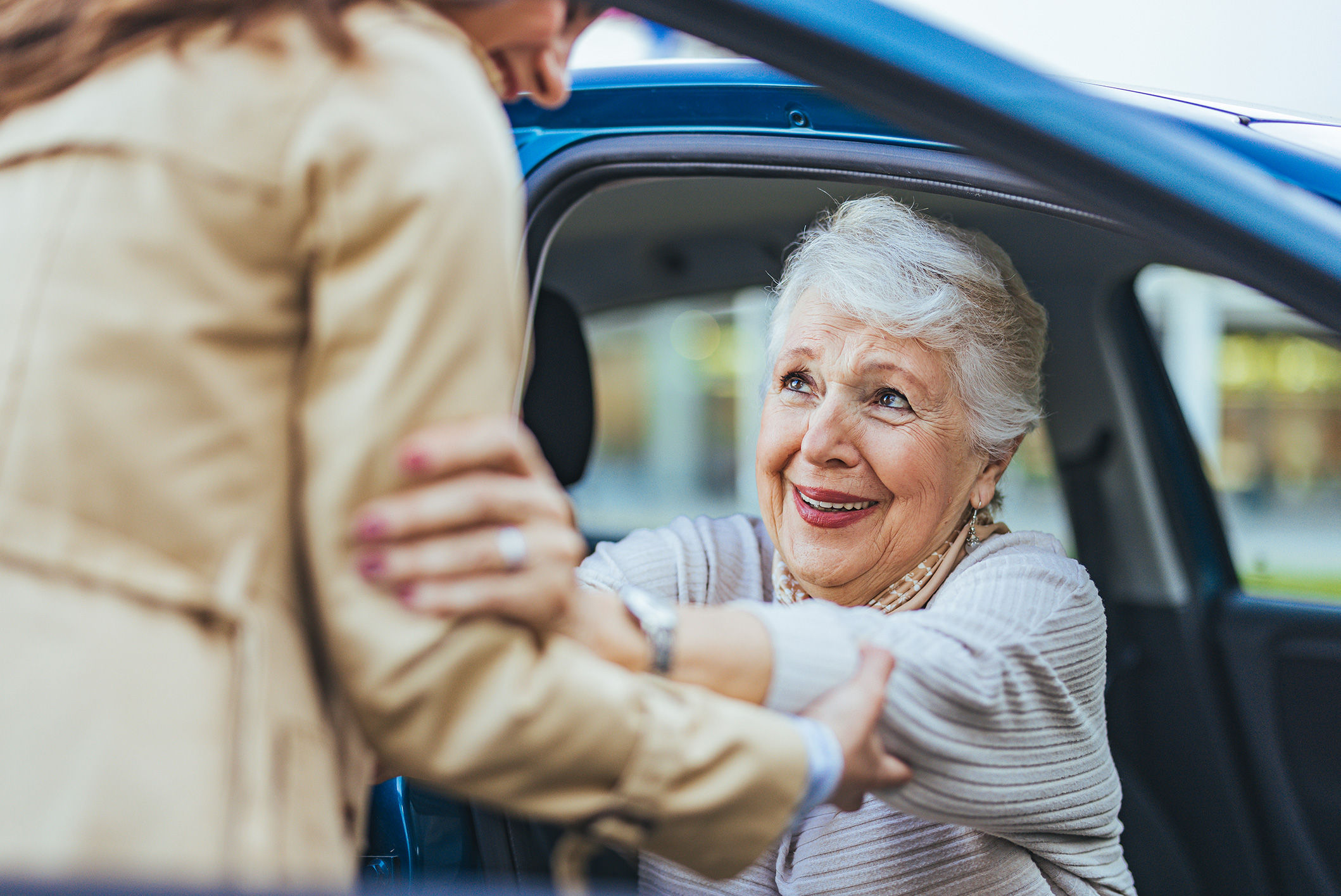 senior woman being assisted out of passenger seat