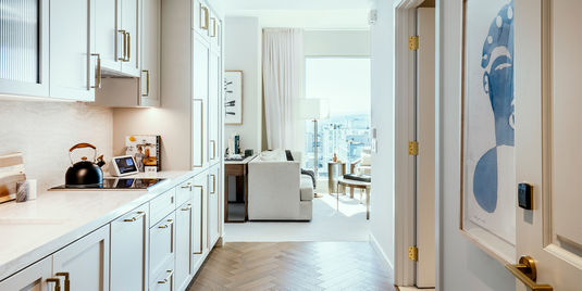 Coterie luxury senior living apartment kitchen and living room with floor to ceiling windows