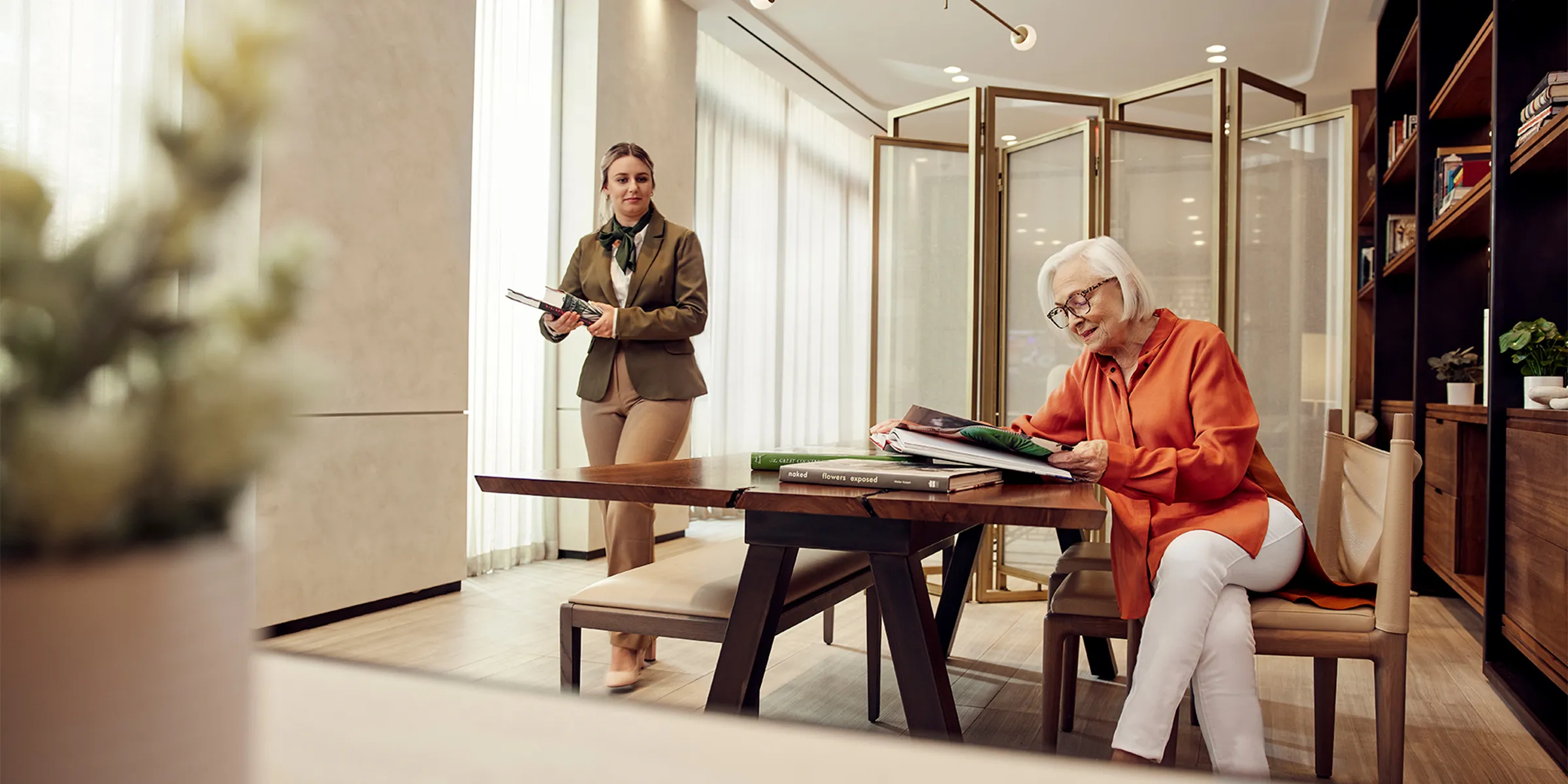 senior living staff member and resident in luxury library