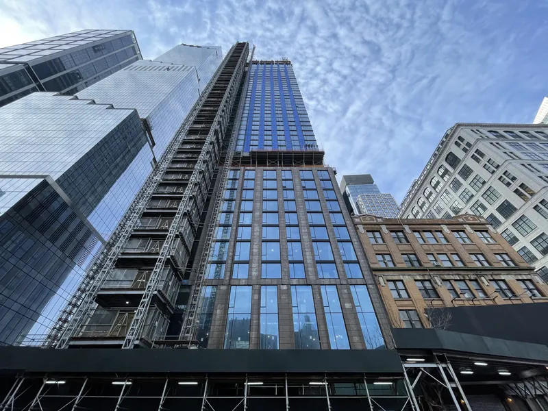 Coterie Hudson Yards exterior facade view. Looking from sidewalk up to sky.