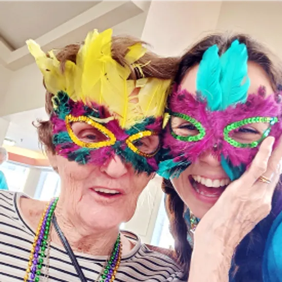 Senior woman and staff enjoying Mardi Gras party