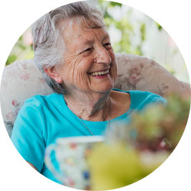 Senior woman laughing while sitting in chair
