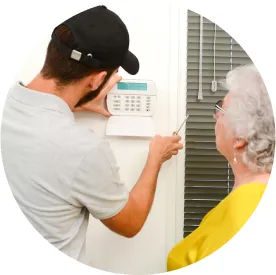 Maintenance technician helping with thermostat in senior resident's room.