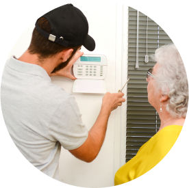 Maintenance man installing home alarm for senior woman