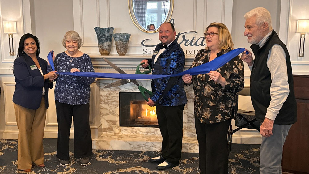 Atria on Roslyn Harbor staff and residents cutting ribbon at the grand community renovation unveiling
