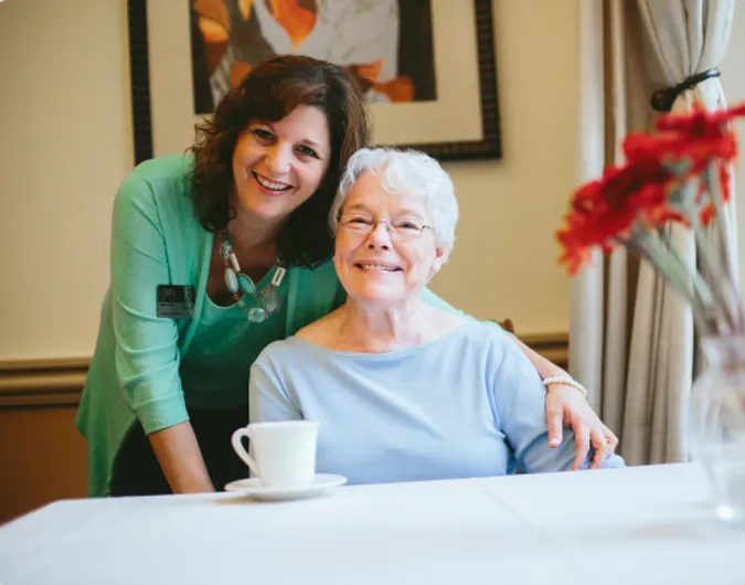 Senior woman and Atria employee smiling together
