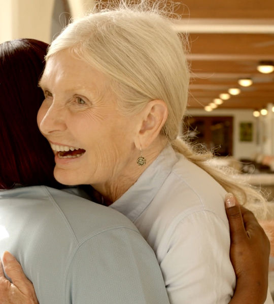 Senior woman hugging friend