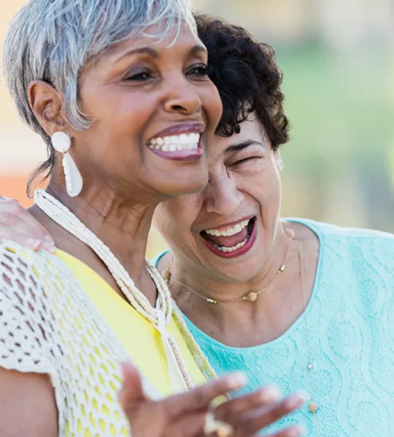 Two senior residents laughing while participating in an activity
