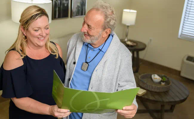 Senior man and daughter looking at brochure