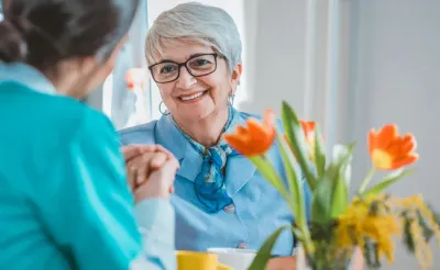 Senior resident talking with caregiver.