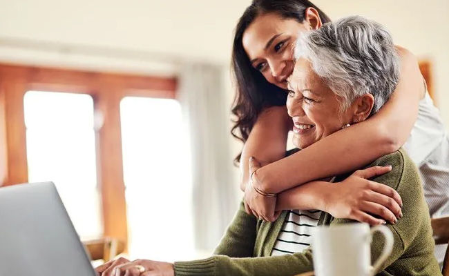 Young adult hugging senior mom