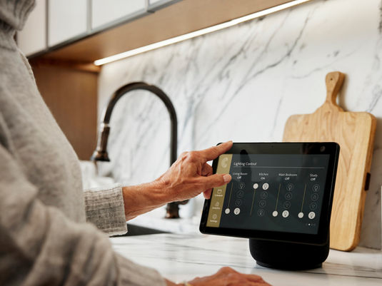 Coterie resident using touchscreen technology in kitchen