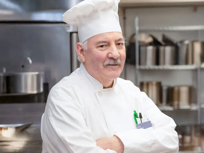 Chef Edward in the kitchen with his arms crossed and smiling
