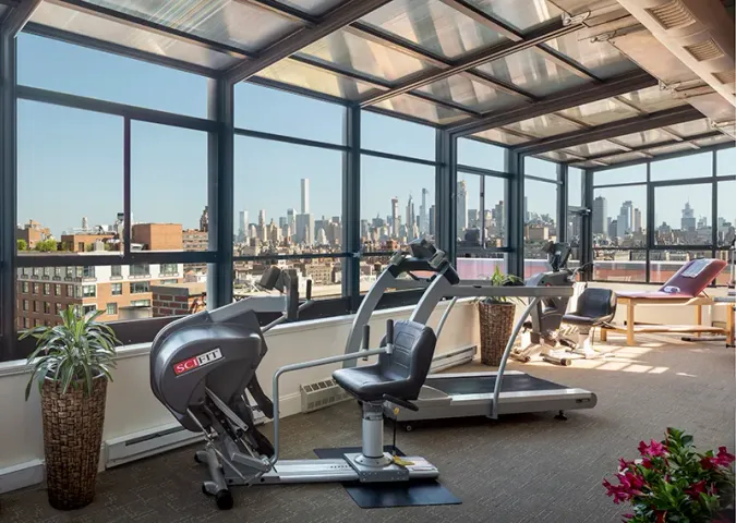 Atria West 86 fitness room with floor to ceiling windows and fitness equipment throughout