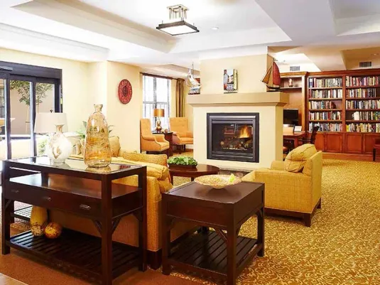 Cozy senior living lounge space at Atria San Juan with inviting fireplace and seating
