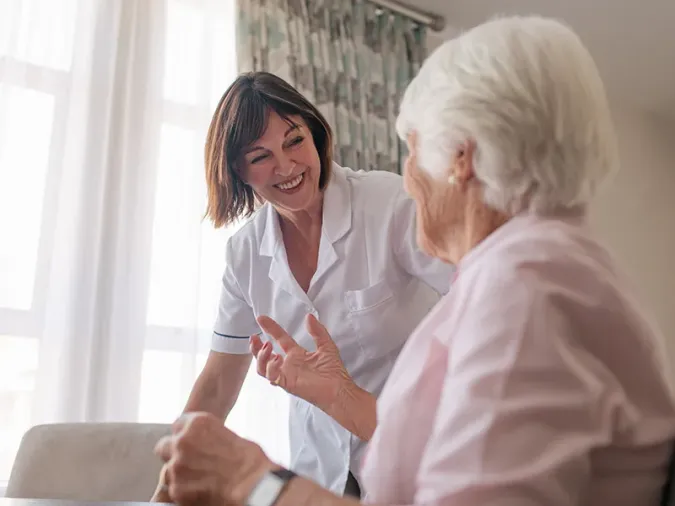 Speech therapist working with senior resident.