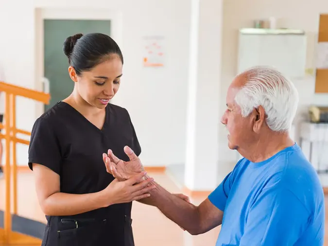 Physical therapist working with resident's arm and wrist