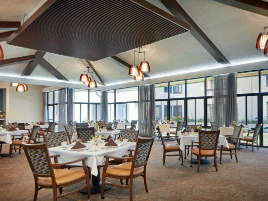 Dining room at Atria Park of San Mateo retirement housing with large windows