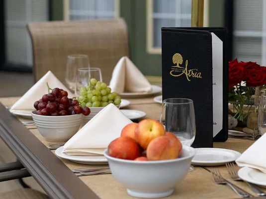 Atria Sugar Land table set for dinner with wine glasses, fruit bowls, menus and napkins.