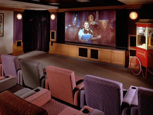 Movie theatre at Atria Park of Sierra Pointe. Includes large movie screen, theatre seating and popcorn machine.