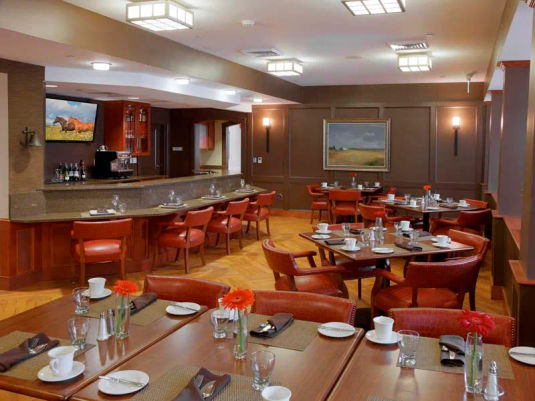 Atria Woodbriar Place pub with bar, bar seats, tables and a tv.