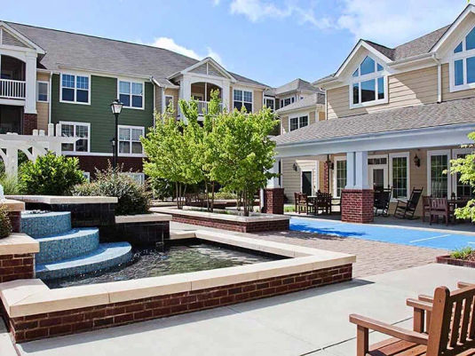 Southpoint Walk Senior Living courtyard with water fixture, covered outside patio and seating.