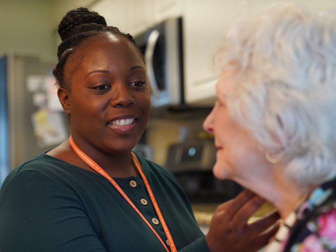 Speech therapist working with senior resident.