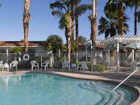 Atria Palm Desert swimming pool, with walk in stairs, fenced in and pergolas