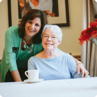 Senior woman and Atria employee smiling together