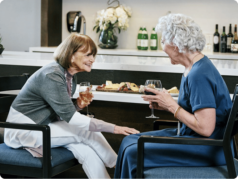 Two Atria residents enjoying wine and cheese together