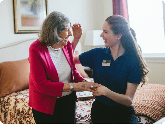 Atria employee helping a resident get ready