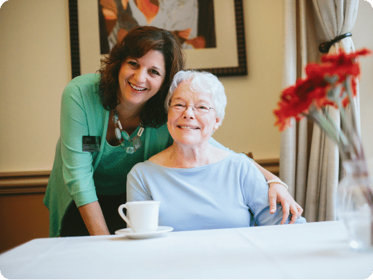 Senior woman and Atria employee smiling together