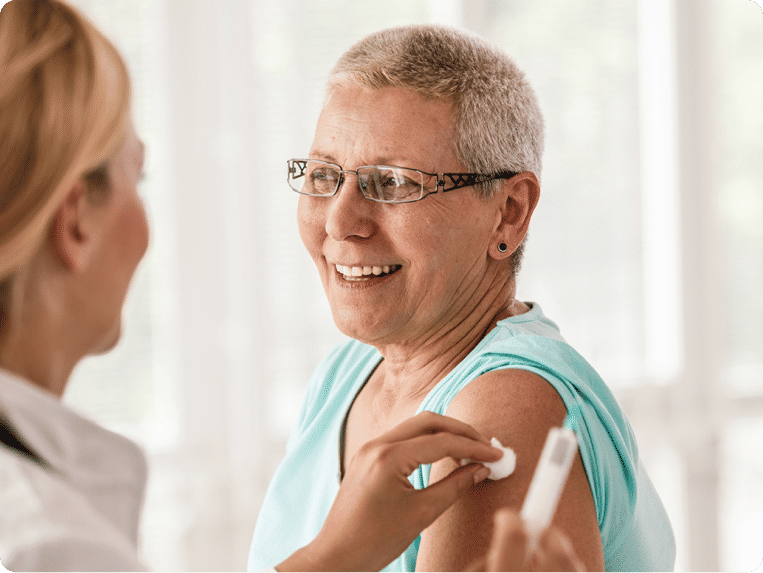 Senior woman receiving a vaccine from a nurse