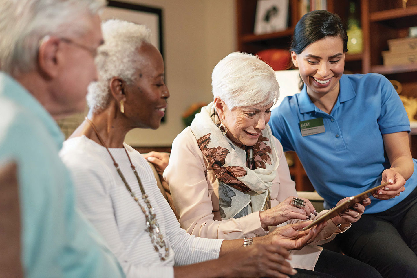 Three Atria Residents looking at an iPad with an employee