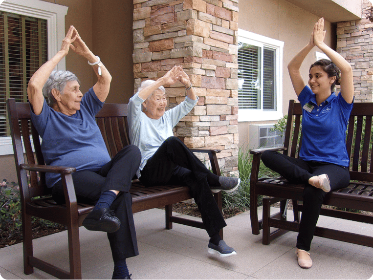 Two senior women and Atria employee practicing yoga