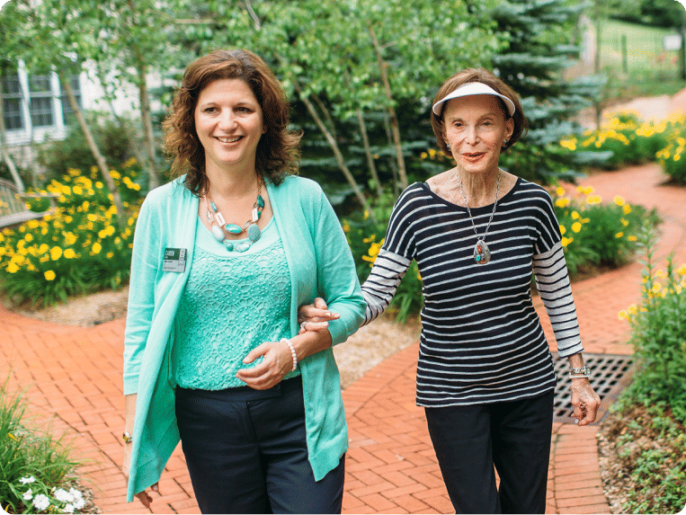 Atria resident and employee taking a walk outside