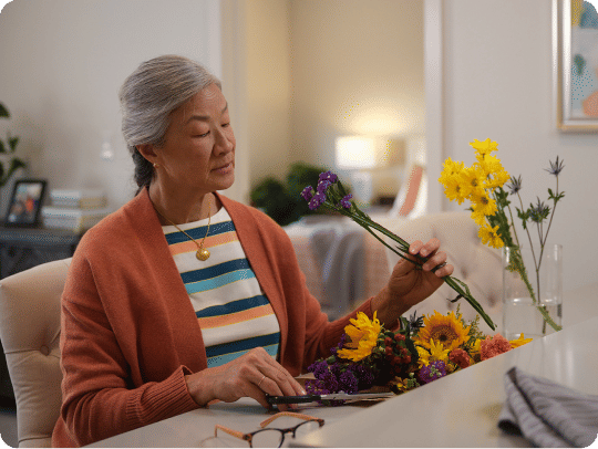 Senior woman arranging flowers in her apartment