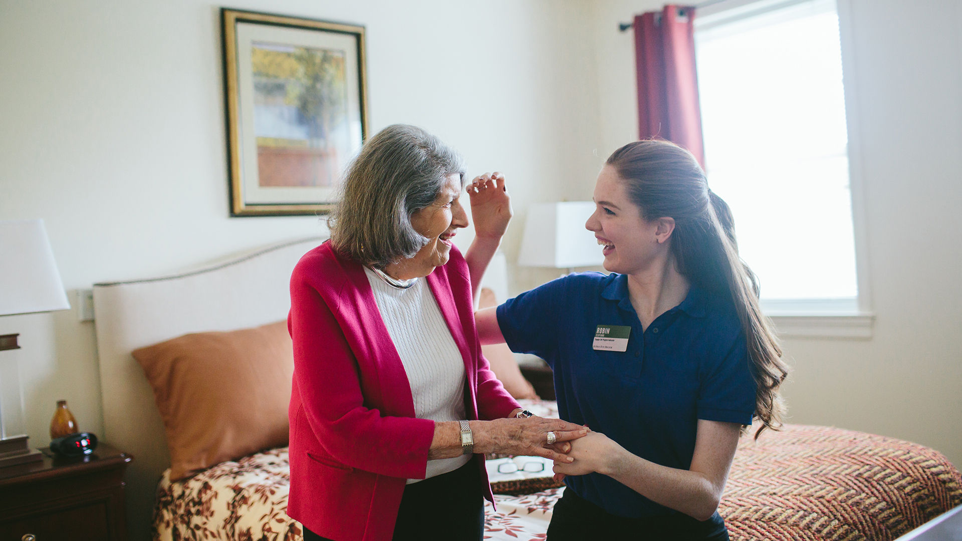 Atria employee helping a resident get ready