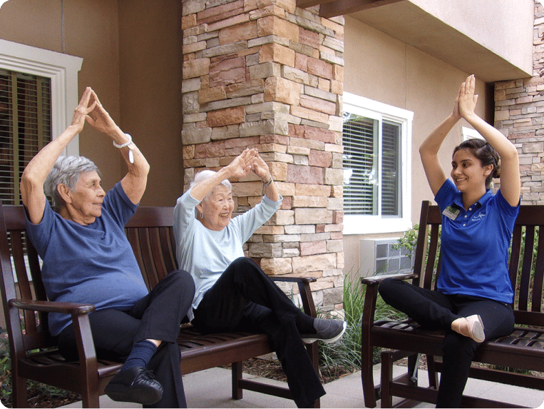 Two senior women and Atria employee practicing yoga