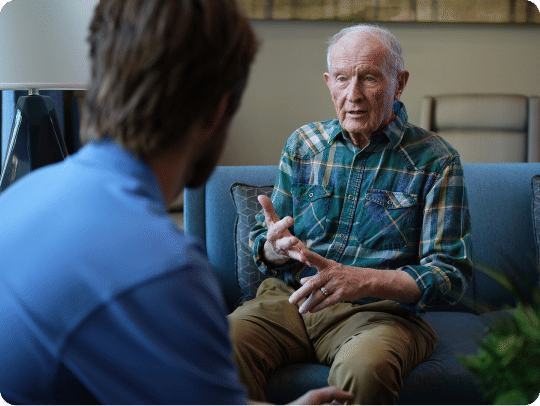 Older man talking with a Atria employee