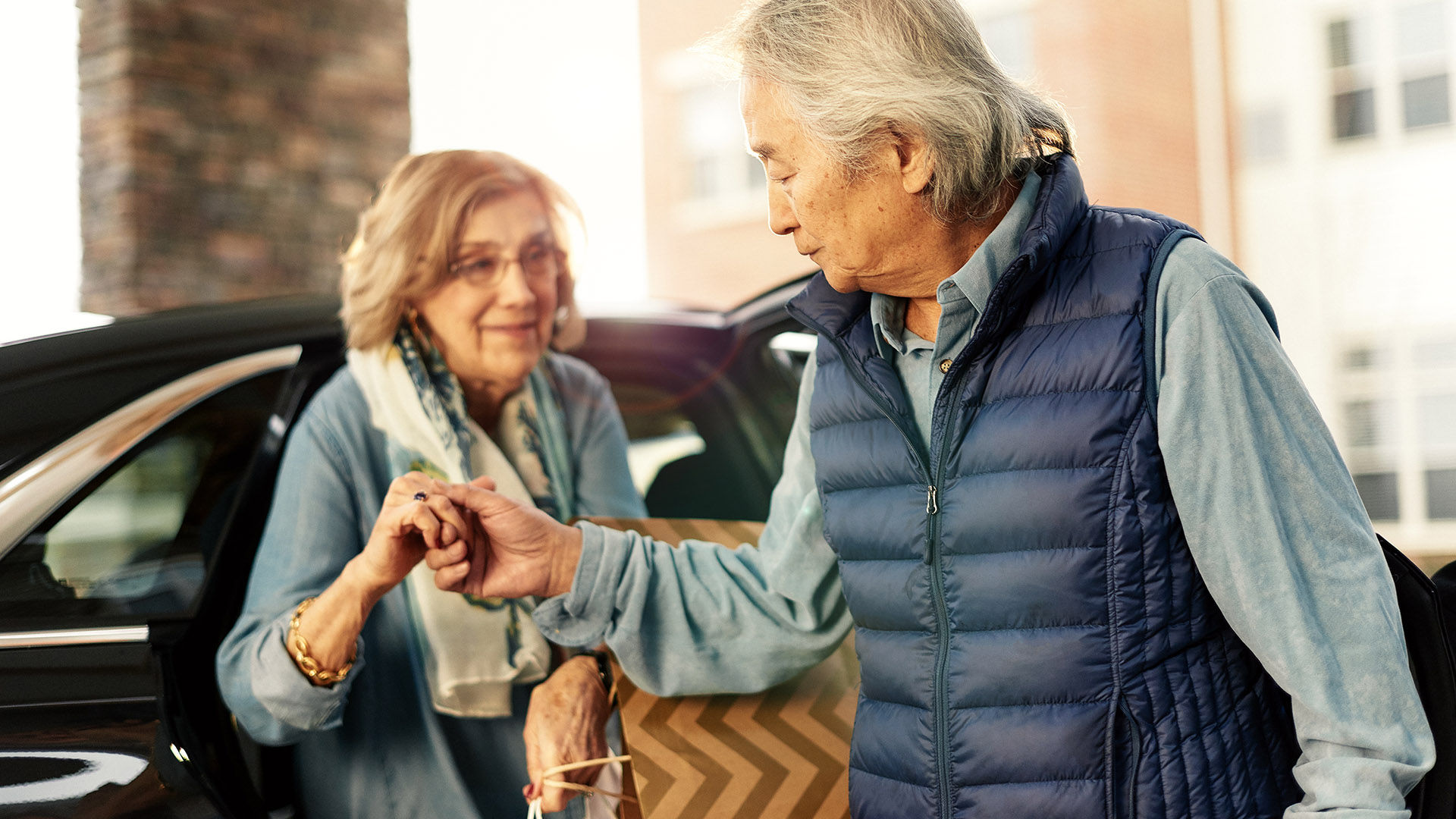 Older man helping an older woman out of the car