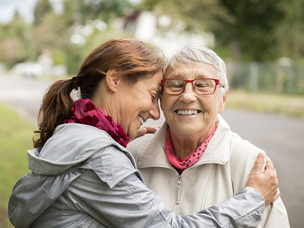 A woman and her daughter hugging and smiling together