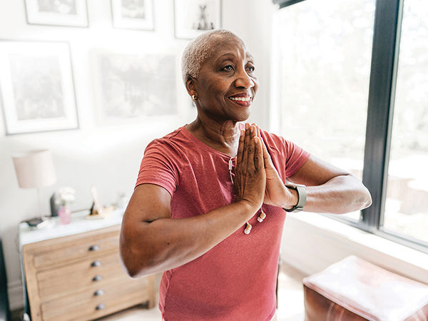 Woman doing yoga in her senior living apartment