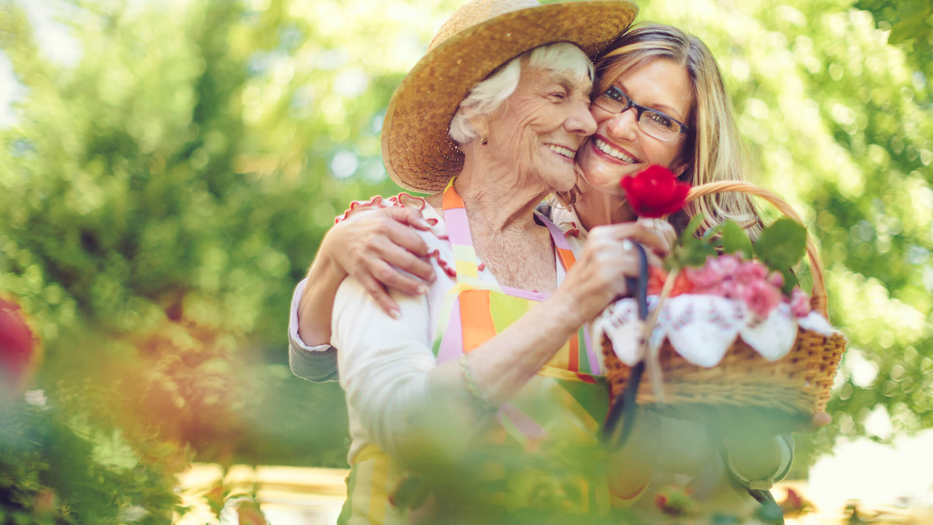 Photo of an older woman and her daughter picking flowers