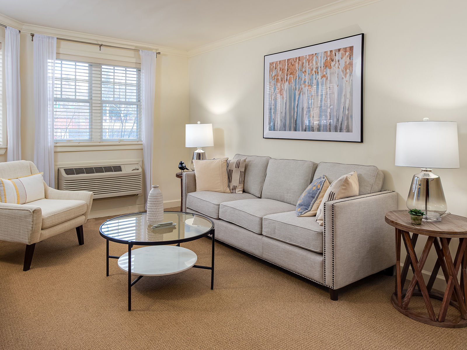 Atria Glen Cove spacious one bedroom apartment living room with couch, coffee table, and reading chair