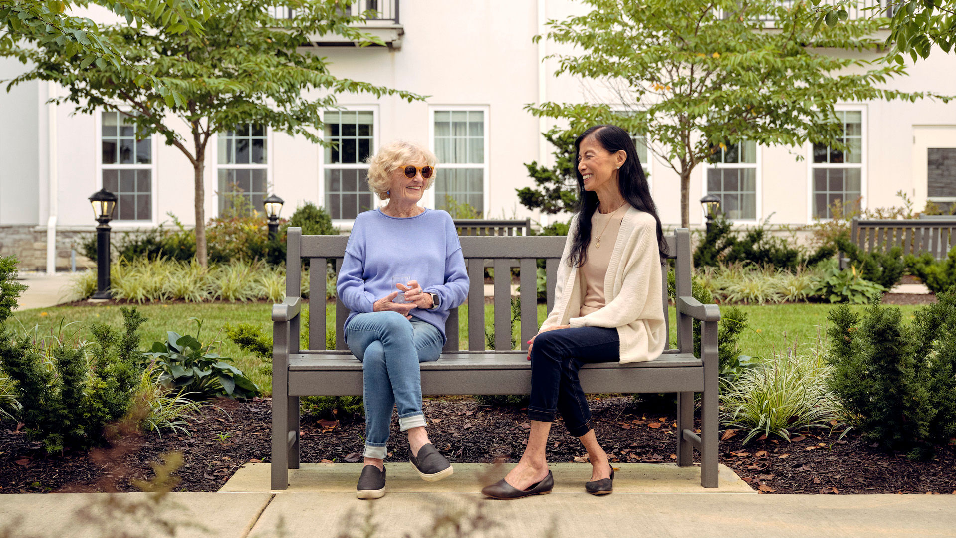 Two women sitting on a bench talking